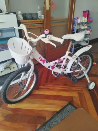 Bicicleta infantil blanca con ruedas de apoyo