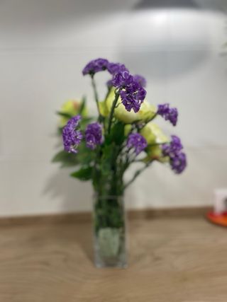 Jarrón con flores artificiales moradas y amarillas