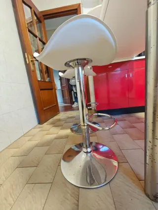 Taburetes altos blancos y plateados