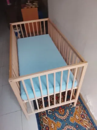 Cuna de madera con colchón azul