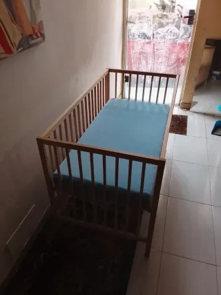 Cuna de madera con colchón azul