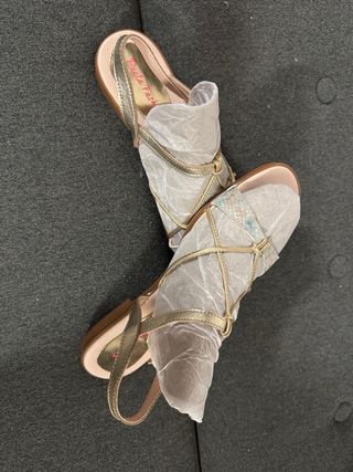 Sandalias doradas y blancas