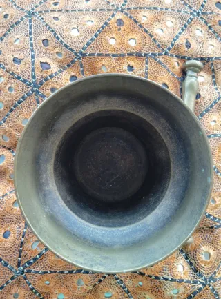 Mortero antiguo de bronce con mano