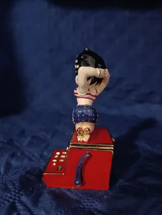 Statuina di Betty boop seduta sulla slot machine.