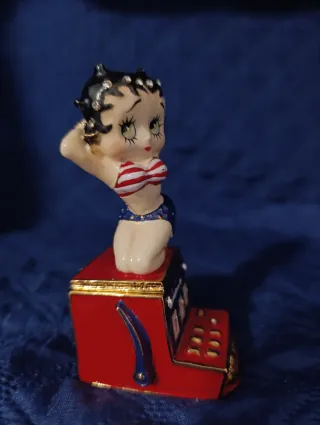 Statuina di Betty boop seduta sulla slot machine.