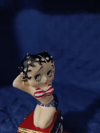 Statuina di Betty boop seduta sulla slot machine.