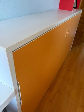 Cama abatible blanca y naranja.