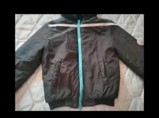 Cazadora reversible negra con capucha.