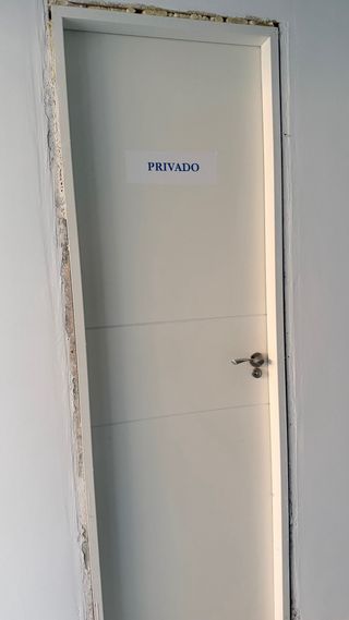 Puerta blanca con cartel PRIVADO