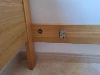 Cama individual de madera con colchón.