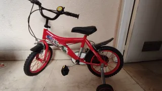 Bicicleta infantil roja, con ruedines