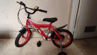 Bicicleta infantil roja, con ruedines