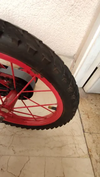 Bicicleta infantil roja, con ruedines