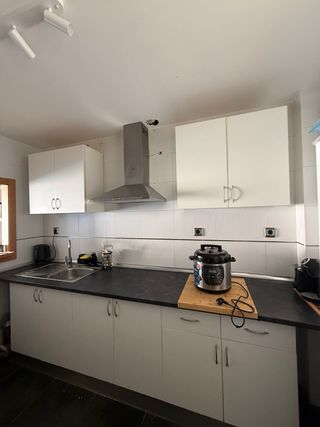 Cocina completa con grifo y encimera.