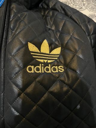 Chaqueta de adidas negra con detalles dorados