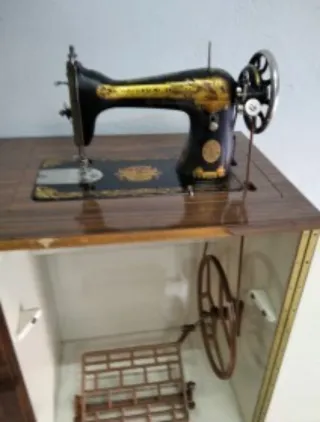 Máquina de coser antigua que funciona con mueble
