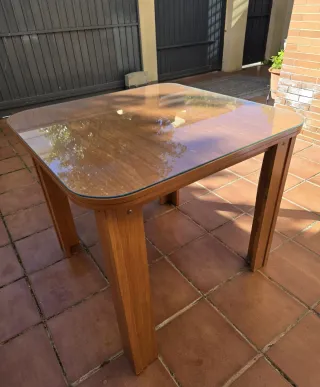 Mesa de madera con cristal de regalo y ropa camill
