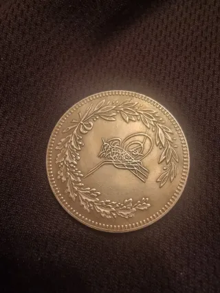 Moneda Antigua con Diseño de Ciudad Fortificada
