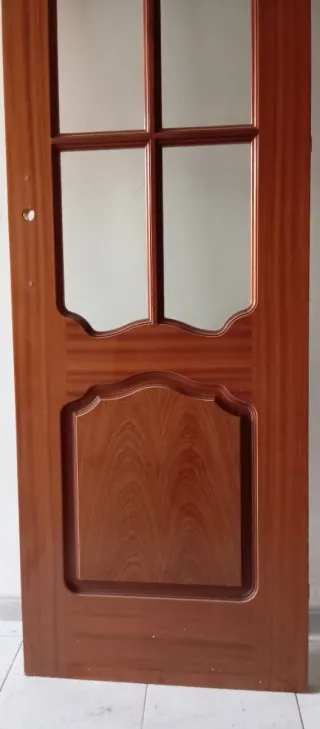 Puerta de madera con cristales sin tirador.