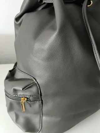 Mochila gris con hebilla dorada