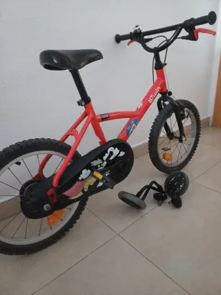 Bicicleta infantil roja con ruedines