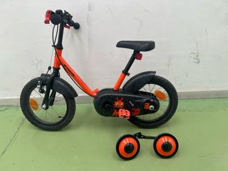 Bicicleta infantil naranja con ruedines