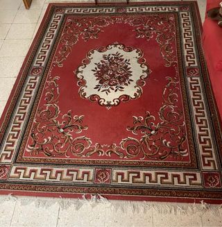 Alfombra roja con diseño floral y greca