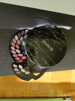 Estuche de maquillaje Douglas negro y dorado.