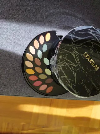 Estuche de maquillaje Douglas negro y dorado.