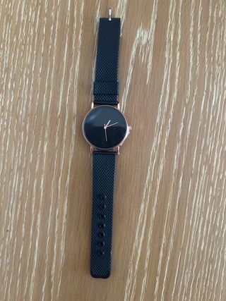 Reloj negro con detalles en color cobre.