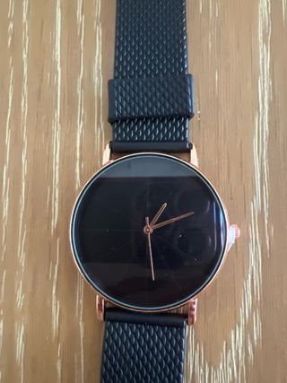 Reloj negro con detalles en color cobre.