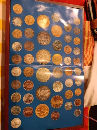 Colección de monedas antiguas enmarcada.