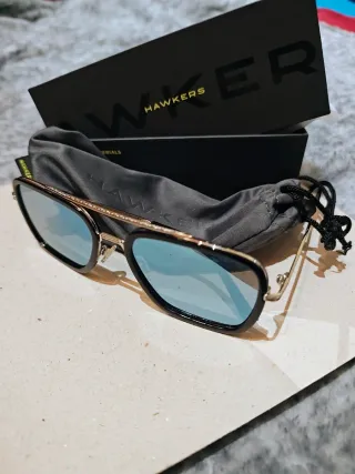 Gafas de sol Hawkers negras y doradas. POLARIZADAS