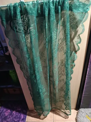 Cortina de encaje verde con diseño floral.