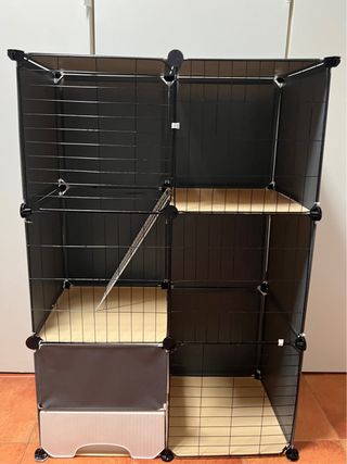 Jaula grande para mascotas negra, beis y blanca.