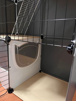 Jaula grande para mascotas negra, beis y blanca.