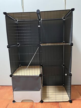 Jaula grande para mascotas negra, beis y blanca.