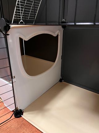 Jaula grande para mascotas negra, beis y blanca.