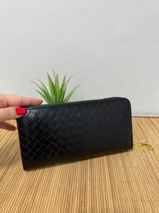 Cartera de mano negra con detalle tejido