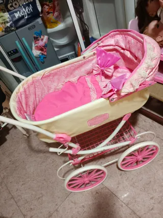 Cochecito de juguete rosa y crema