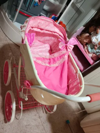 Cochecito de juguete rosa y crema