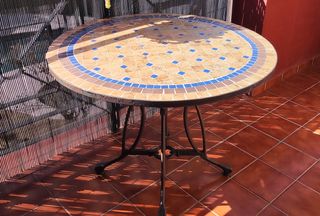 Mesa piedra y metal con sillas.