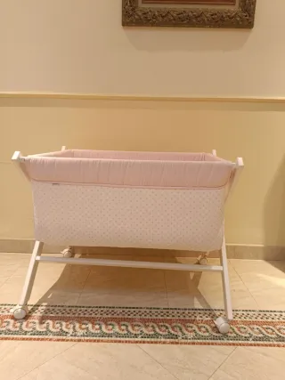 Minicuna con ruedas y vestidura rosa