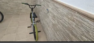 Bicicleta BMX plateada y verde, ruedas 20