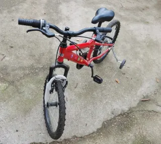 Bicicleta infantil roja con ruedines