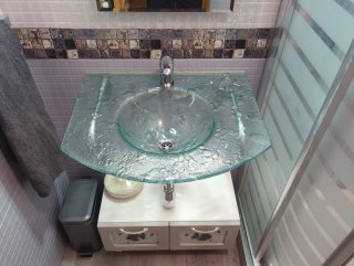 Lavabo cristal, grifo, cajonera y espejo lampara.