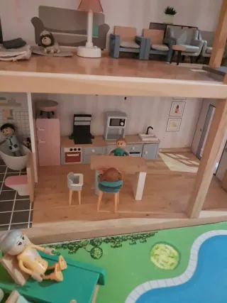 Bella casa delle bambole in legno con piscina e giardino