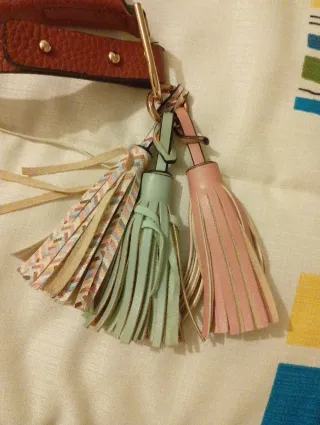 Bolso polipiel marrón, con colgante de borlas