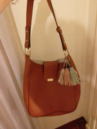 Bolso polipiel marrón, con colgante de borlas