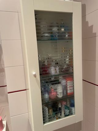 Estantería de pared blanca con puerta de cristal